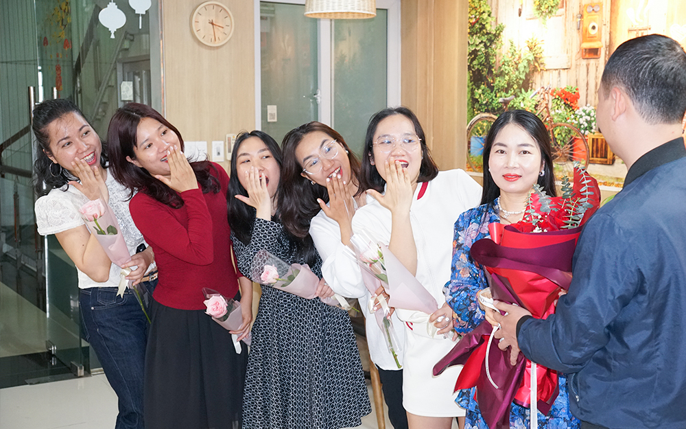 Đại diện cán bộ nam tặng hoa chị em phụ nữ